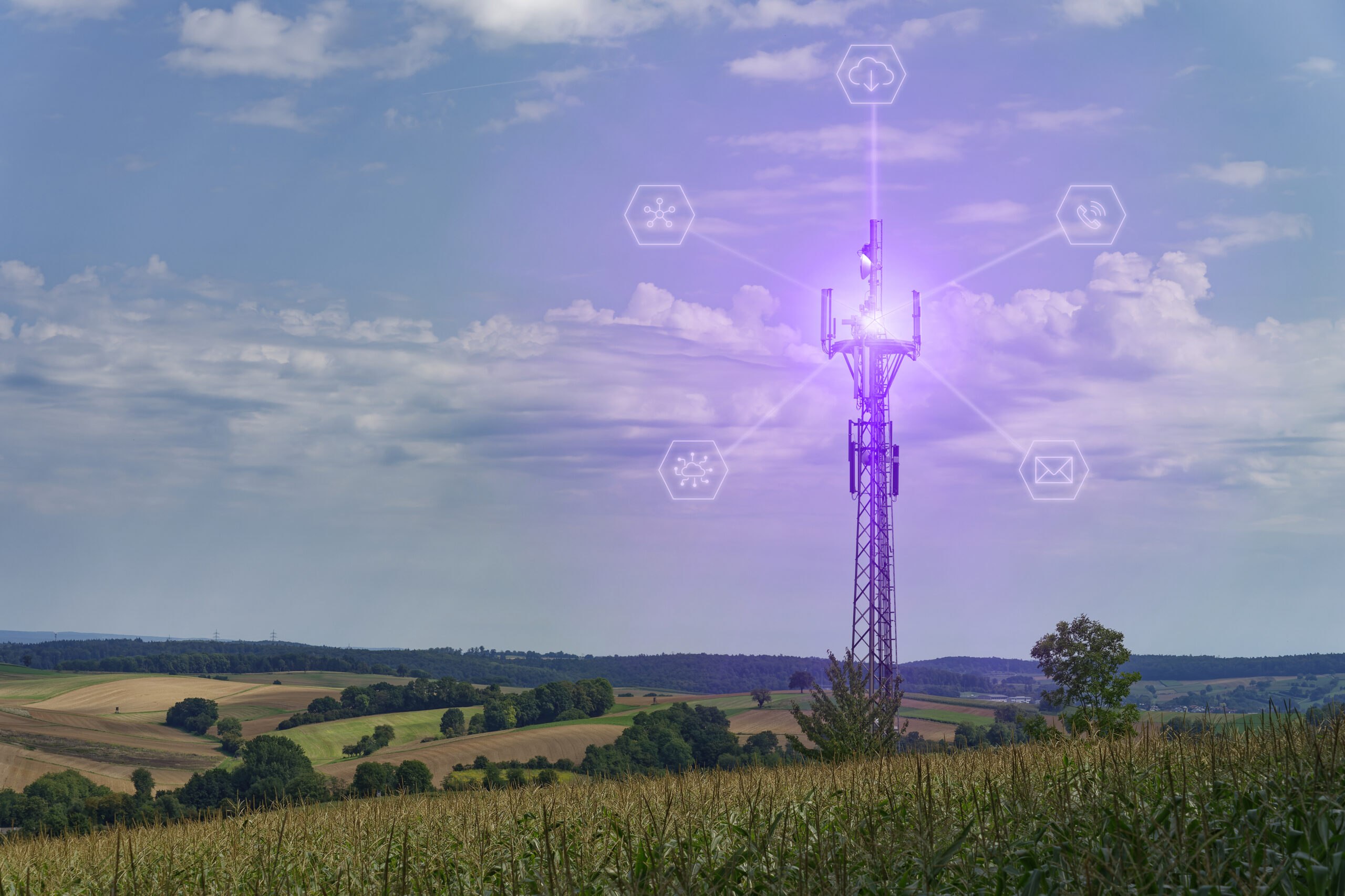 Mobile radio tower in the open nature, with fields, forests and meadows. Virtual icons regarding data connections and access to cloud data, phone, email, networking.